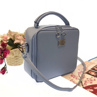 Изящная сумочка-коробочка Blumarin с ремнем через плечо из матовой эко-кожи нежно-голубого цвета.
